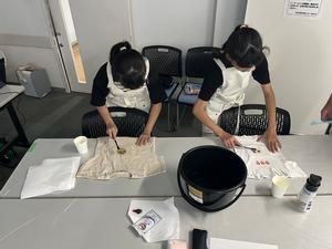 子どもが洋服についた汚れを歯ブラシで落としている様子