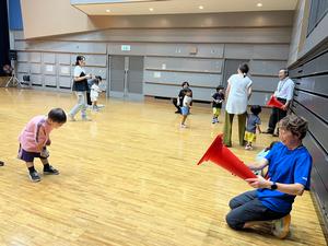子どもが的をめがけて新聞を丸めたボールを投げる様子