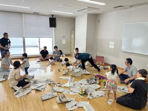子どもが新聞紙で遊んでいる様子