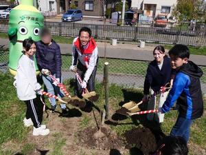 小学生とともに苗木を植樹する市長