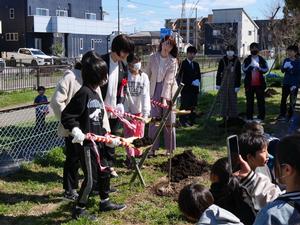 小学生とともに苗木を植樹する教育長
