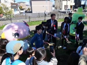 小学生とともに苗木を植樹する校長先生