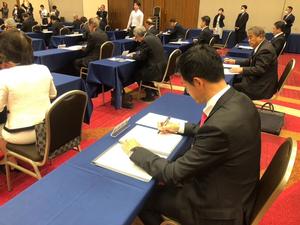 協定書にサインをする市長