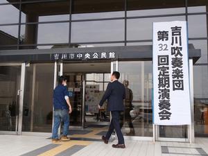 演奏会の立て看板が掲げられた中央公民館入口から入館する市長