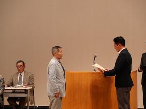 壇上で退任される方に感謝状を渡す市長