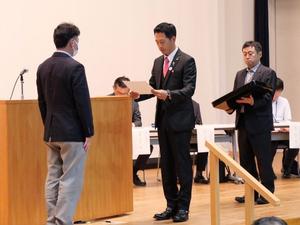 壇上で委嘱書を交付する市長