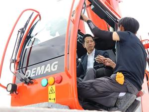 クレーン車の運転席に座り、説明を受ける市長