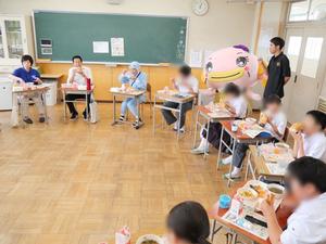 机を円にしてみんなでなまずドッグを食べる様子