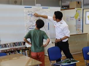 市域図に集まる児童に説明をする市長