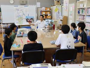 写真を用いて児童に説明する市長