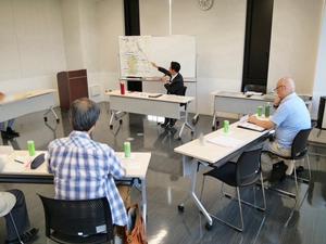 ホワイトボードを用いて説明する市長
