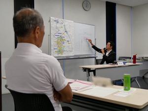 市長の説明を真剣な様子で聞く研究員