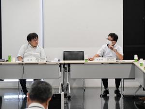 会議で意見を述べる委員