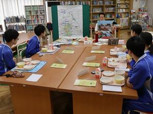 ラミネート写真を手に生徒たちに説明する市長