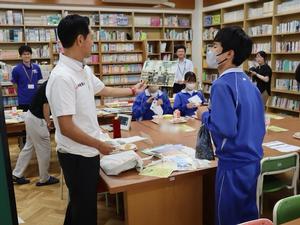 小学生のときに参加した生徒さんにそのときの写真を見せる市長