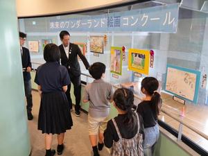 絵画展示会場で受賞された皆さんと絵を鑑賞する市長
