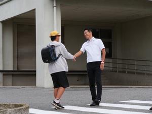 少年消防クラブで全国3位を成し遂げた児童と握手をして祝福する市長