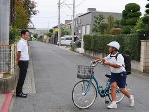 登校する生徒に笑顔で挨拶をする市長