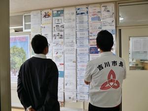 廊下に掲示されている生徒のプレゼン資料を見る市長