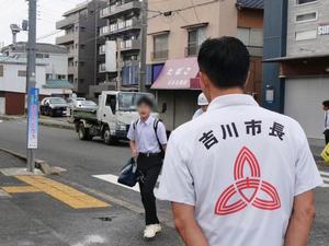 登校する生徒に笑顔で挨拶をする市長