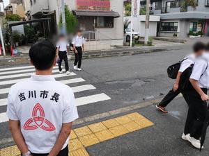 登校する生徒に笑顔で挨拶をする市長