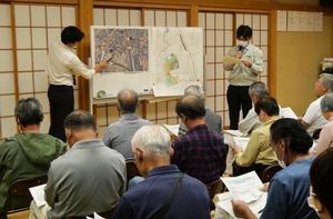 指し棒で市域図を指して説明する職員