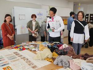 フリーマーケットに並べられた書籍を見る市長