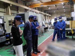 工場内を見学し、説明を受ける市長
