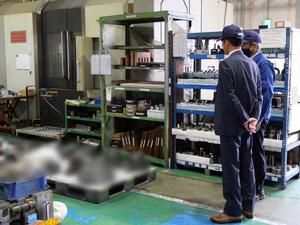 工場内を見学し、説明を受ける市長