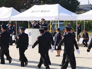 行進する消防団員に壇上より敬礼する市長