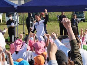 市長の掛け声でみんなで拳を突き上げてオーと叫ぶ様子