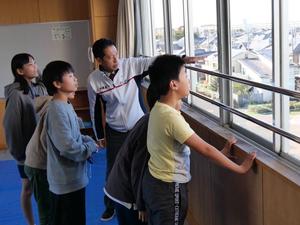 窓から見える市長室を教える市長