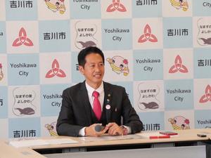 笑顔で記者の質問を聞く市長