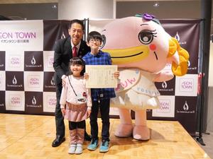 受賞者の児童とその家族と市長との記念撮影