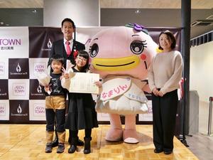 受賞者の児童とその家族と市長との記念撮影