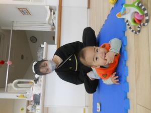 うつ伏せでカメラに向かって笑顔を見せる男の子の写真