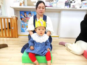 5月生まれの女の子が冠をかぶって積み木に座っている様子