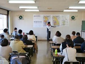 図を指示棒で指して説明する市長