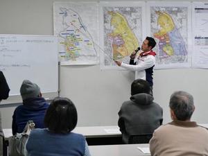 指示棒で地図を指して説明する市長