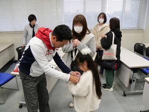 会場に来てくれた児童にバッジをつけてあげる市長