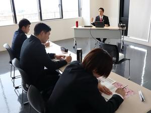 市長講話を聞いてメモを取る新規採用職員