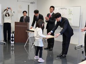 教育部長から受賞者に記念品を贈呈する様子