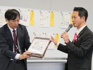 記念品のリバーシについて説明する市長