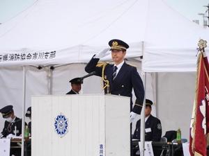 壇上で敬礼する市長