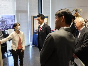展示会場で職員に説明を受ける市長、副市長、参与