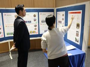 展示会場で職員に説明を受ける市長