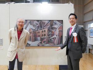 優秀賞の大久保さんと作品の前で記念撮影をする市長