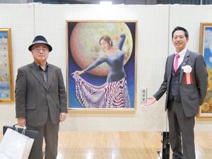優秀賞の峯さんと作品の前で記念撮影をする市長