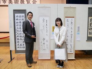 最優秀賞の水野さんと作品の前で記念撮影をする市長