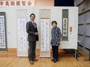 優秀賞の森さんと作品の前で記念撮影をする市長
